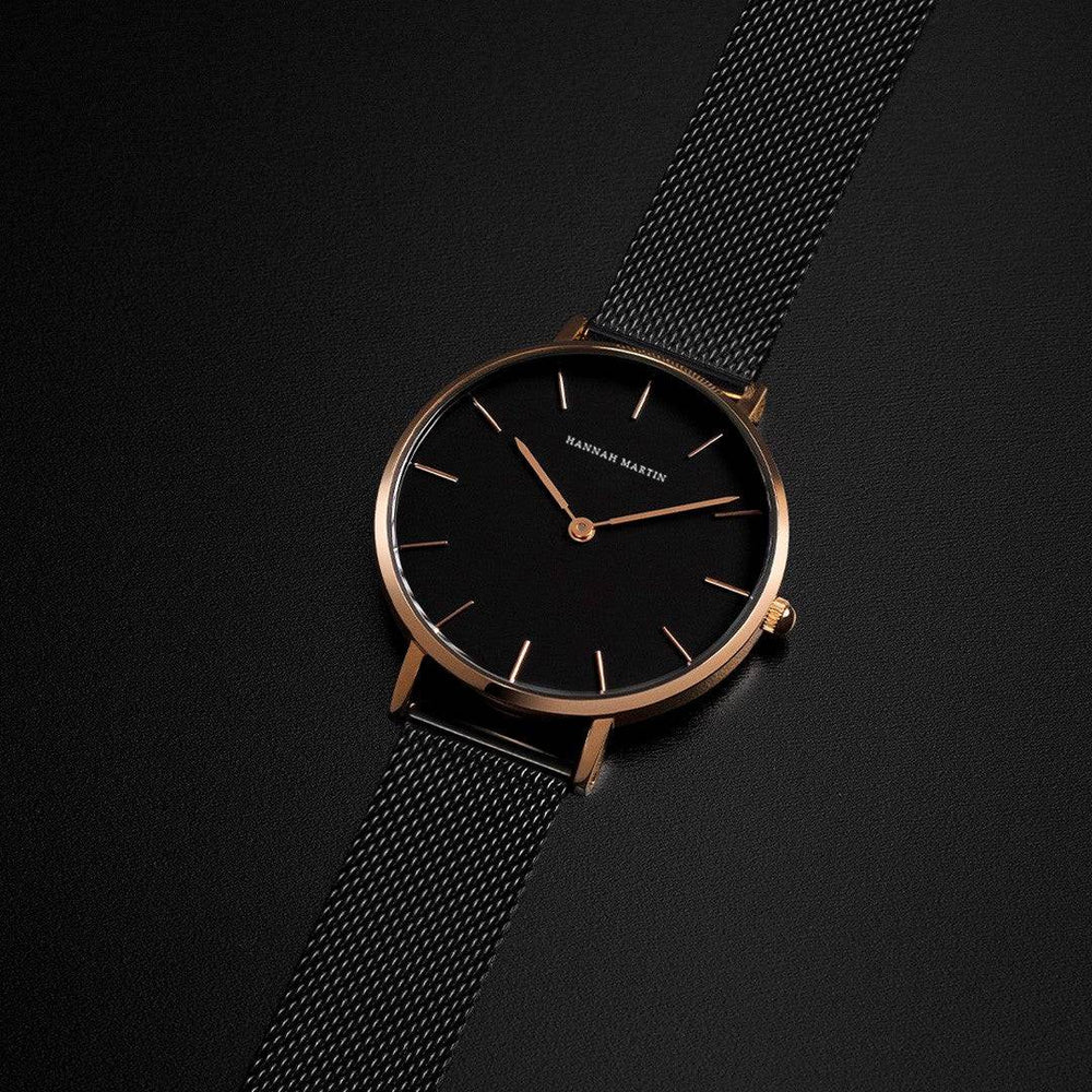 un reloj negro y dorado sobre una superficie negra