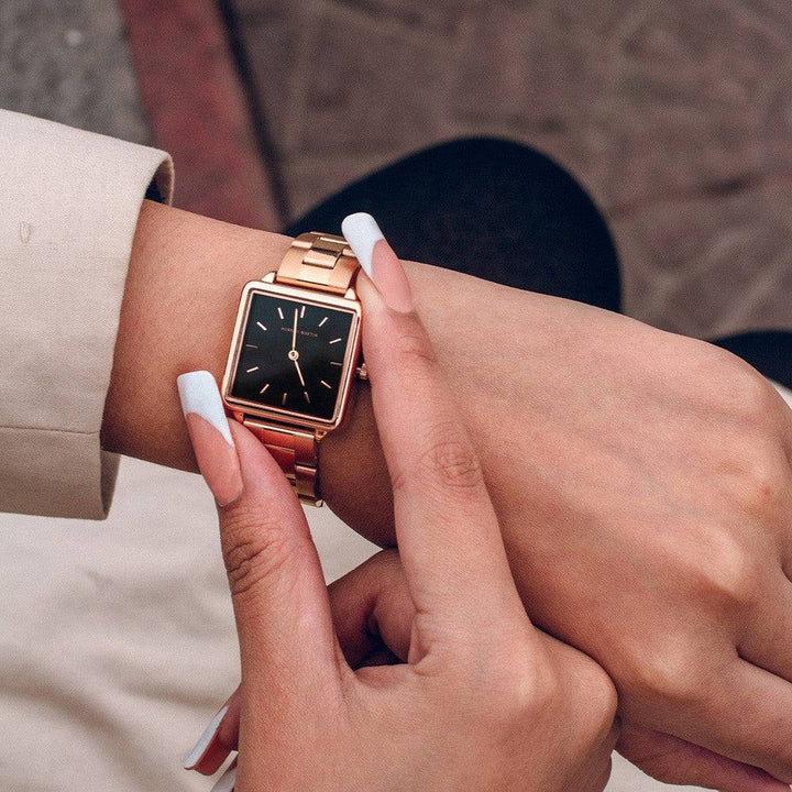 a woman wearing a gold watch on her wrist